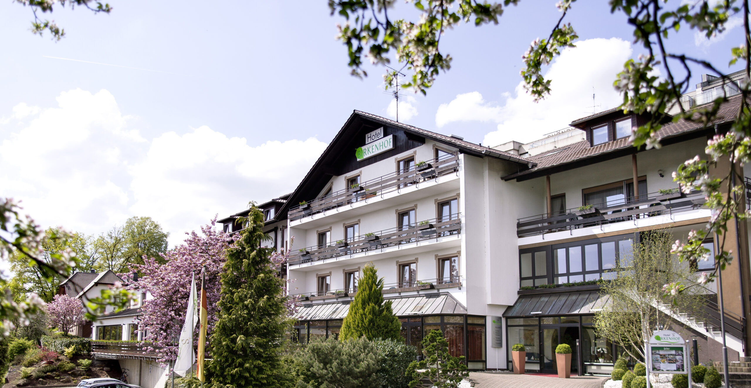 Hotel Birkenhof in Bad Soden-Salmünster mit Blick auf den Kurpark und einem Eingang mit Fassade mitten im Spessart